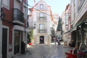 an alley with people walking down a street with buildings at Apart Baía do Sado I in Setúbal