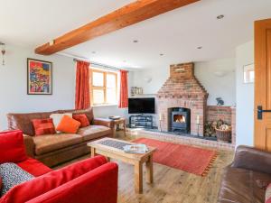 a living room with a couch and a fireplace at Grooms Cottage in Leicester