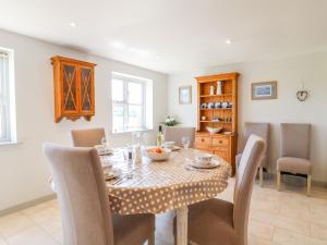 een eetkamer met een tafel en stoelen bij Grooms Cottage in Leicester