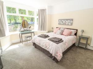 1 dormitorio con cama, escritorio y ventana en Park View en Llandudno