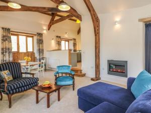 a living room with blue furniture and a fireplace at The Old Smithy in Honiton