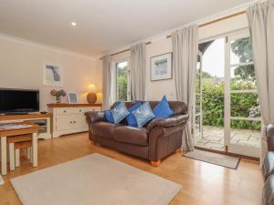 a living room with a leather couch and a television at Deja Blue in Falmouth