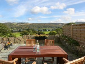 a wooden table with two chairs and a bottle of wine at Two Lake View in Coniston