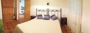 ein Schlafzimmer mit einem Bett mit zwei blauen Kissen darauf in der Unterkunft Alojamiento Mirador del Castillo in La Iruela