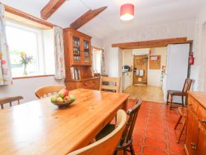 a kitchen with a wooden table with a bowl of fruit on it at Poldowrian Farmhouse in Helston