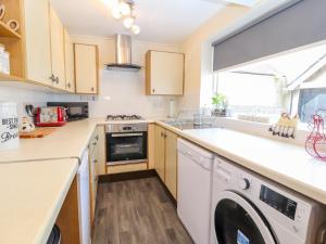 a kitchen with a washer and dryer next to a window at Park View in Llandudno