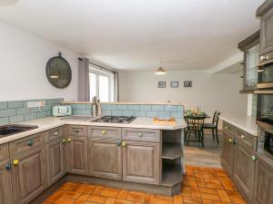 a large kitchen with wooden cabinets and a table at Ivy Cottage in Darlington