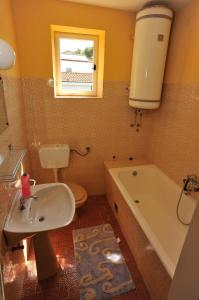 a bathroom with a sink and a tub and a toilet at Apartments Mar - 50 m from beach in Sutivan