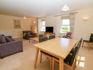 sala de estar con mesa de madera y sillas en Tirionfa, en Llangefni