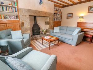 a living room with two couches and a fireplace at Poldowrian Farmhouse in Helston