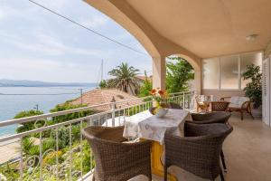 a balcony with a table and chairs and a view of the ocean at Apartments Matea - 20m from sea in Bol