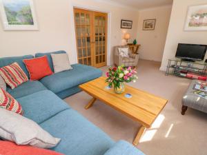 a living room with a blue couch and a coffee table at Henrys Croft in Helston