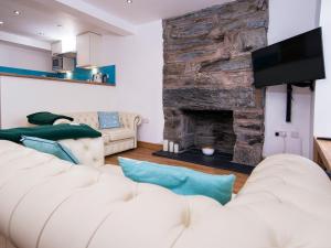 ein Wohnzimmer mit 2 weißen Sofas und einem Steinkamin in der Unterkunft The Captain's Bank in Porthmadog