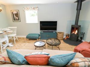 a living room with a couch and a fireplace at Overlea Cowshed in Highpeak Junction