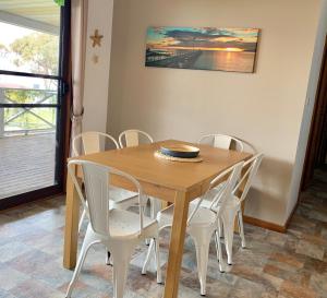 a wooden table and chairs in a room at Fareview Beach House in Emu Bay