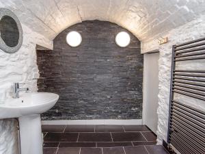 ein Badezimmer mit Waschbecken und einer Ziegelwand in der Unterkunft The Captain's Bank in Porthmadog + 39 Fotos