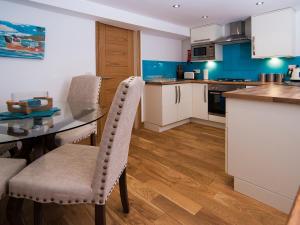 a kitchen with a table and chairs in a room at The Captain's Bank in Porthmadog