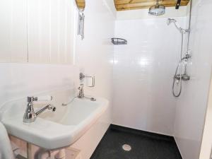 a white bathroom with a sink and a shower at The Gypsy in St Asaph