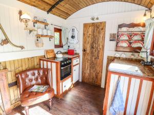 a kitchen with a stove and a chair in a room at The Gypsy in St Asaph