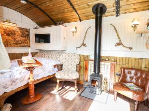 ein Schlafzimmer mit einem Bett und einem Holzofen in der Unterkunft The Gypsy in St Asaph