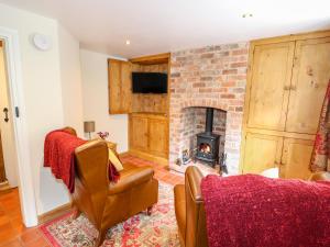 a living room with a brick fireplace and a couch at Lizzies Cottage in Horncastle