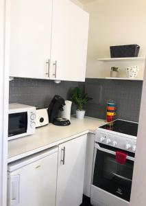 a kitchen with white cabinets and a stove top oven at Lovely Flat Champs de Mars Eiffel in Paris