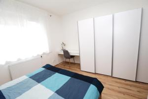 a bedroom with a bed and four wardrobes at Šamorín - apartment in the center - free parking in Šamorín