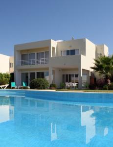 a large swimming pool in front of a house at Villas Oceano in Albufeira