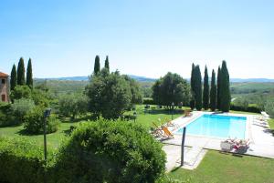 a swimming pool in a garden with people sitting around it at La Mandriola in Laiatico