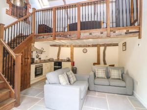 a living room with two chairs and a staircase at The Cart Shed in East Dereham