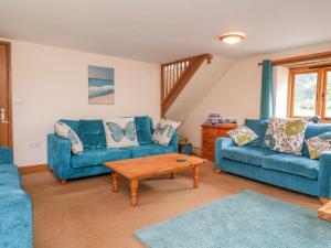 a living room with two blue couches and a coffee table at The Shippon in Barnstaple