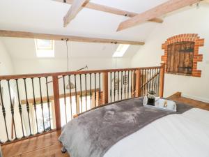 a room with a bed and a balcony at The Cart Shed in East Dereham