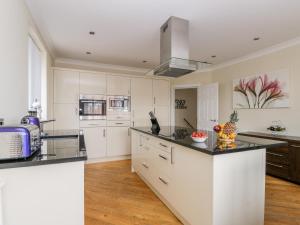 uma cozinha com armários brancos e bancadas pretas em The Gansey Girl em Bridlington