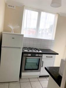 a kitchen with a stove and a white refrigerator at AC Lounge 115 in Rochford