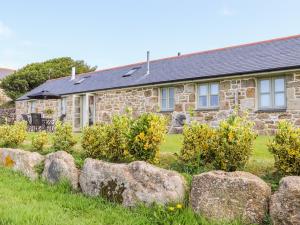 ein Steinhaus mit Felsen davor in der Unterkunft Pen Tewan in Penzance