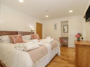 a bedroom with a large bed with towels on it at Rowan in Truro