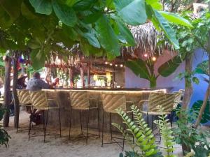 un bar en la playa con gente sentada en él en Junto al Rio Bungalows & Suites, en Sayulita