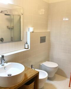 a bathroom with a sink and a toilet and a mirror at The Suite in Santa Maria Navarrese
