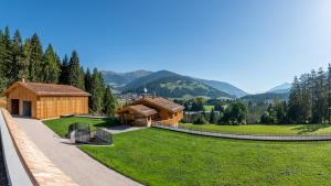 ein Haus in den Bergen mit einem grünen Hof in der Unterkunft Tubla - Hof Maistatt in Toblach