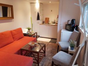 een woonkamer met een oranje bank en een tafel bij Bonjour Copenhagen in Herlev