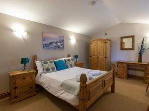 een slaapkamer met een groot bed en houten meubilair bij Riverhouse Lodge in Upwey
