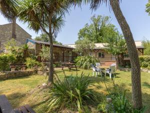 ein Haus mit einem Picknicktisch und Palmen in der Unterkunft Riverhouse Lodge in Upwey