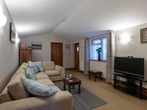 een woonkamer met een bank en een flatscreen-tv bij Riverhouse Lodge in Upwey