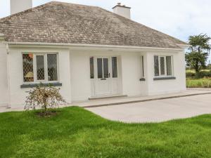 a white house with a green lawn at Dirreen House in Athea