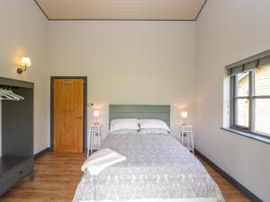 ein Schlafzimmer mit einem großen Bett und zwei Fenstern in der Unterkunft Primrose in Glastonbury