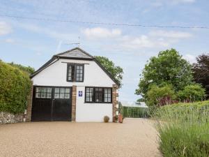 a white house with a black garage at Little England Cottage in Milborne Saint Andrew