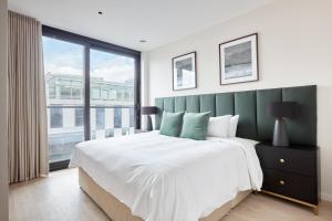 a bedroom with a large bed and a large window at Sonder at Britain Quay in Dublin