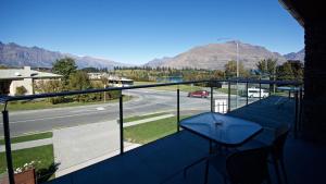 a balcony with a table and a view of a street at Autoline Queenstown Motel in Queenstown