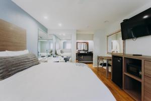 a bedroom with a large white bed and a mirror at Scottish Inn & Suites - Kemah Boardwalk in Kemah