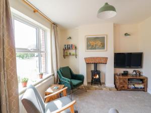 a living room with a fireplace and a television at Sea View Cottage in Frinton-on-Sea